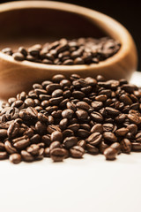 Closeup of Blurred Wodden Bowl With Roasted Coffee Beans Over Bl