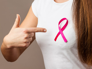 woman in t-shirt with pink cancer ribbon pointing