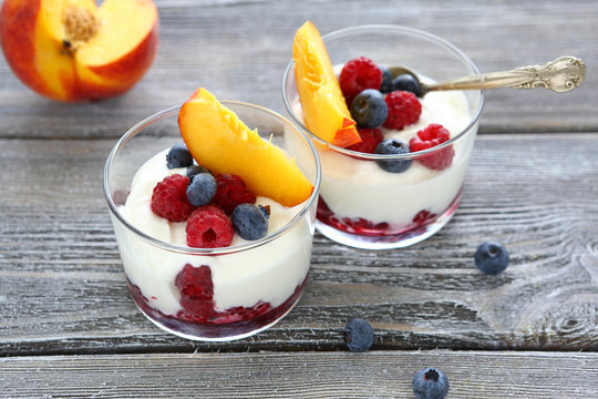 Yogurt with peach slices raspberries and blueberries
