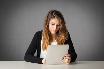 Woman using tablet against grey grunge background.