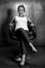 Monochrome photo of sexy woman in chair looking at camera