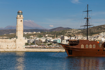 Sailing ship on the background of a lighthouse in Greece