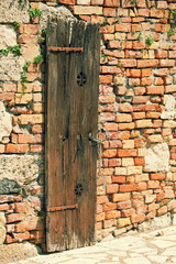 Brick wall of the old house with a wooden door