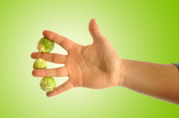 hand grabbing three brussels sprouts