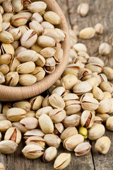 full bowl of pistachio on wooden surface