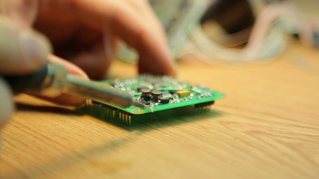 Scientist soldering pads on the device close-up