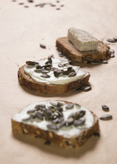 Different kinds of bred with cheese spread and pumpkin seeds