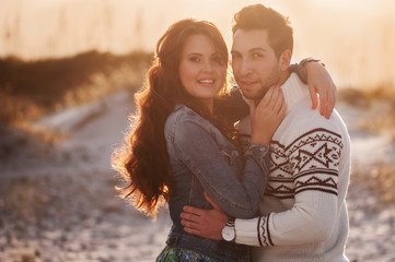 Lovely young couple on the sunset beach, selective focus