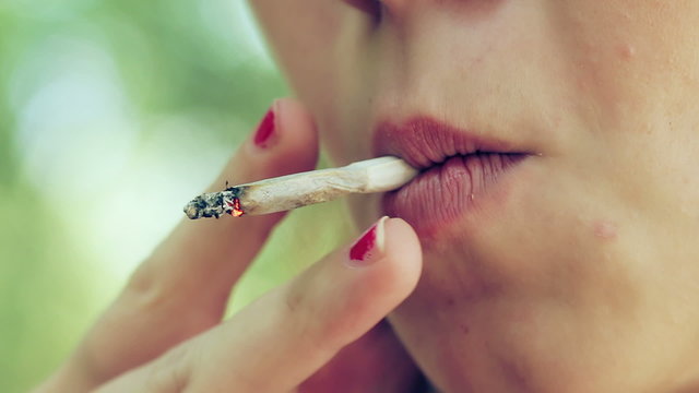 sexy young woman smoking a joint - close up