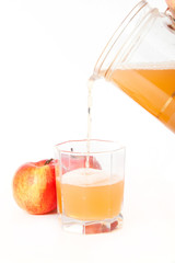 Jug of freshly squeezed apple juice, glass and two apples