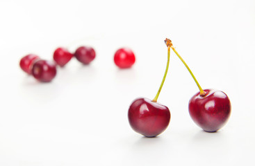 two isolated red cherries and other in blur