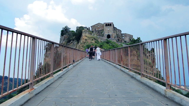 tourists walking on a uphill road  to reach a medieval village - steep - hill