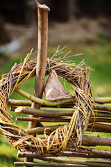willow wreath with fabric chicken on fence in garden