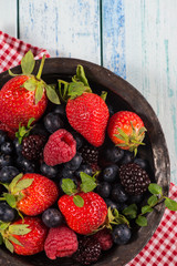 Fresh summer berries fruits in vintage bowl on rustic table