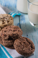 brown and white cookies with glass of fresh milk