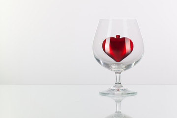 Red heart inside a glass of cognac