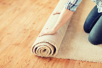 close up of male hands unrolling carpet