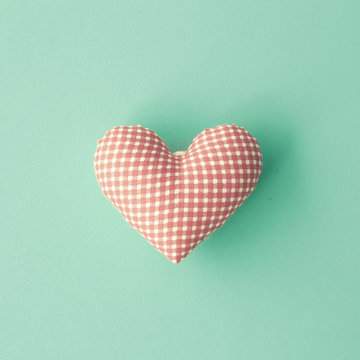 Vintage cotton stuffed heart over blue background