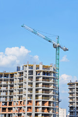 Fototapeta premium Crane and building construction site against blue sky