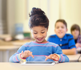little school girl with tablet pc over classroom