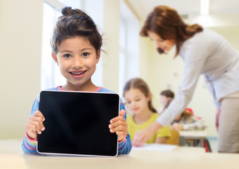 little school girl with tablet pc over classroom