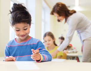 Obraz na płótnie Canvas happy little school girl over classroom background