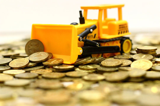 yellow toy bulldozer rakes rubles