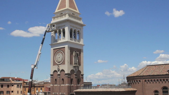 bricklayer on boom lift to work on the bell tower of a church - crane - worker