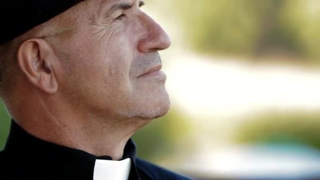Old pastor wearing a black shirt and clerical collar