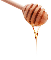 Honey dripping from a wooden honey dipper isolated on white back
