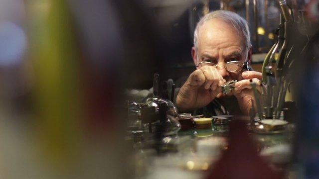 Watchmaker examines old  watch