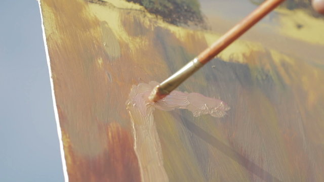 close up of a brush that paints a canvas - painter