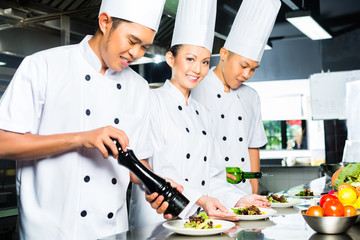 Asian Chef in restaurant kitchen cooking