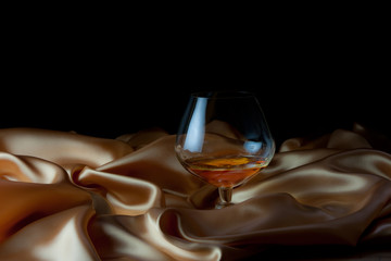 Glass of cognac on the silk