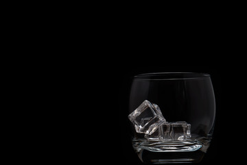 Empty glass filled with ice cubes; black and white
