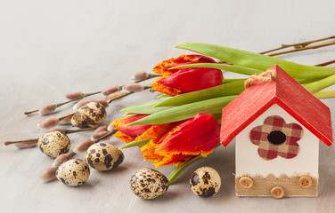 Easter eggs with birdhouse and spring flowers