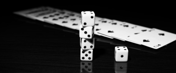 A gambler rolling the dice to win. on a reflective surface with 