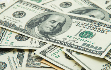 One hundred dollars pile as background.
