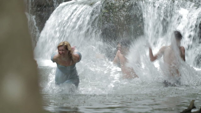 boys and girls are having fun in a river - waterfall in backgroung