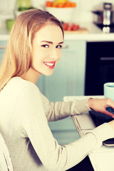 Beautiful woman sitting by the table with laptop