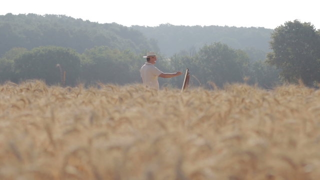 painter in the middle of a wheat field paints a beautiful landscape, canvas