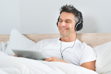 Man Enjoying Music On Headphone Holding Digital Tablet