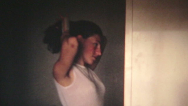 vintage scene of a young woman who combs and smiles