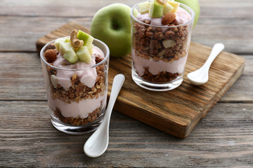 Healthy layered dessert with muesli and berries on table