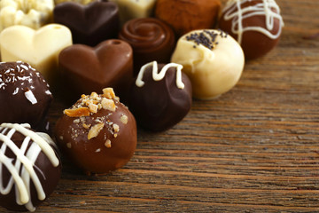 Delicious chocolate candies on wooden background