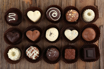Delicious chocolate candies on wooden background
