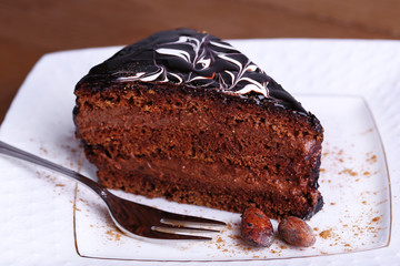 Delicious chocolate cake on plate on table close-up