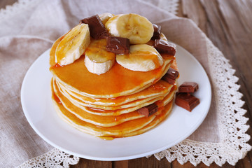 Stack of delicious pancakes with chocolate, honey and slices of