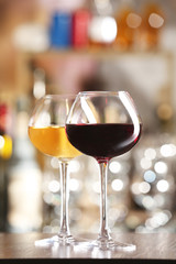 Two glasses of wine with bar on background