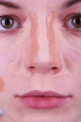 Applying makeup with cosmetic foundation, macro